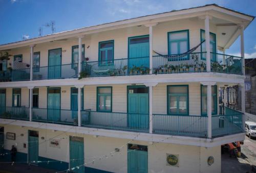 un edificio più vecchio con porte verdi e balcone di Bocas Style Casco Viejo a Città di Panama