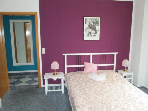 ロストックにあるFerienwohnung Kleine Moeweの紫の壁のベッドルーム1室(ベッド1台付)