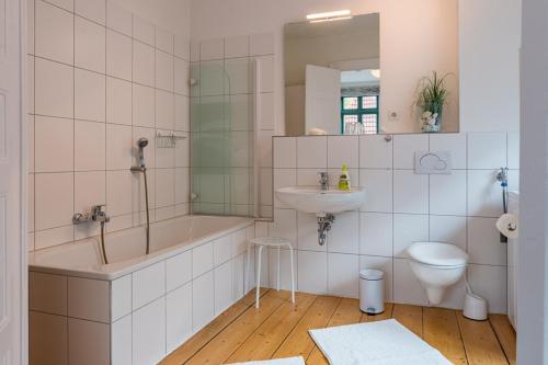 a bathroom with a tub and a sink and a toilet at Feriendomizil am Gänsemarkt in Eckernförde