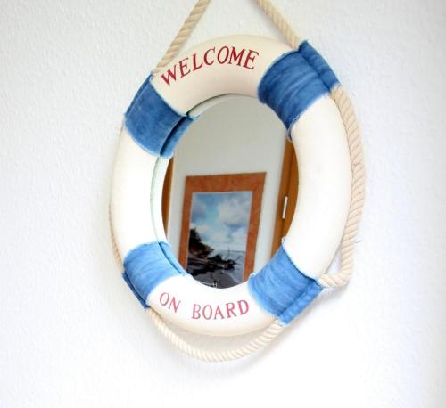 a welcome wreath on a wall with a mirror at Ostseeglück App9 in Zingst