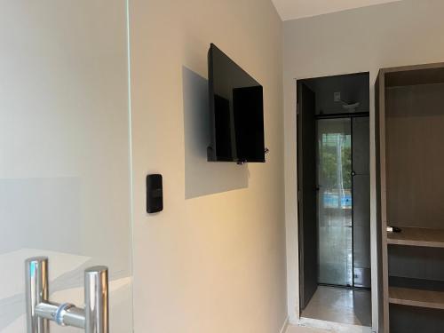 a room with a television on a wall with a door at Pousada Jardins in São Luís