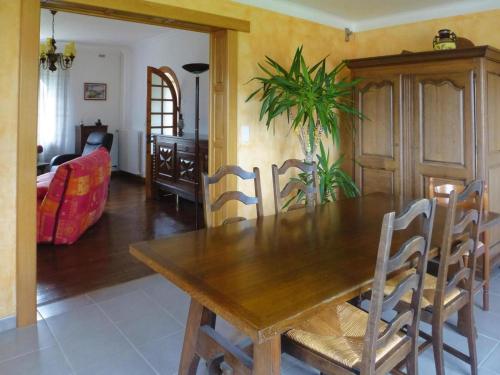une salle à manger avec une table et des chaises en bois dans l'établissement Stone House Pleumeur-Bodou near Pink Beaches, à Pleumeur-Bodou