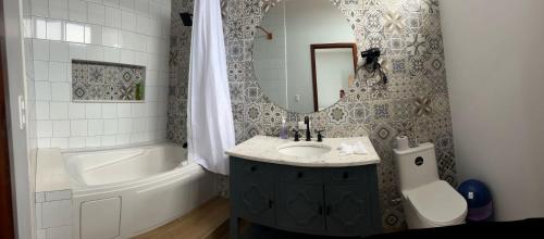 a bathroom with a sink and a tub and a mirror at La Isla Bonita Residence in Flores