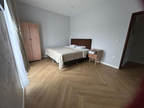 a bedroom with a bed and a wooden floor at La Isla Bonita Residence in Flores