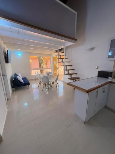 una cucina e un soggiorno con tavolo e sedie di Villas Gasparico Playa Gasparico a La Sabana
