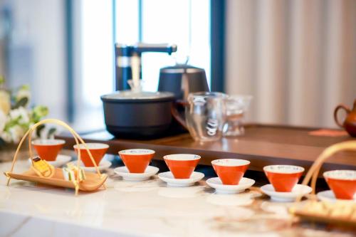 a group of cups of orange juice on a counter at Citadines Science City Guangzhou-Shuttle bus to Canton Fair Complex during Canton Fair period in Guangzhou