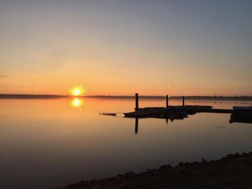 a sunset over a body of water with a dock at Stausee-Haus in Neumühle