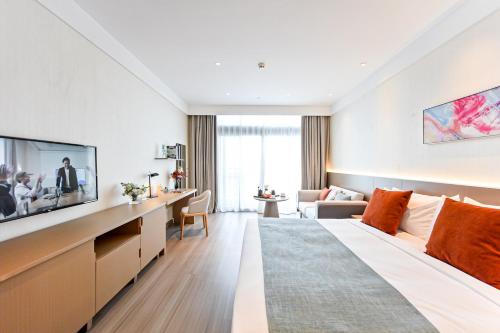 a hotel room with a large bed and a tv at Citadines Science City Guangzhou-Shuttle bus to Canton Fair Complex during Canton Fair period in Guangzhou