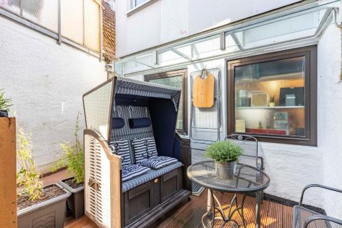 a porch with a chair and a table on a balcony at Haus zum Seiltänzer - Leuchtturm in Eckernförde