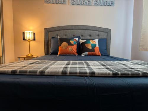 Una cama grande con una manta a cuadros y almohadas. en Peace Stay, en Edmonton