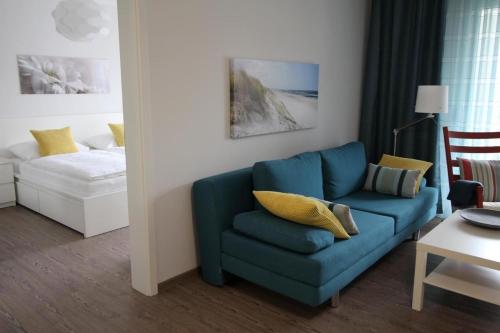 een woonkamer met een blauwe bank en een bed bij Dock 31 in Neuhaus