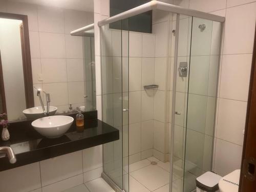 ein Badezimmer mit Glasdusche und Waschbecken in der Unterkunft Iloa Resort Residence 001C in Barra de São Miguel