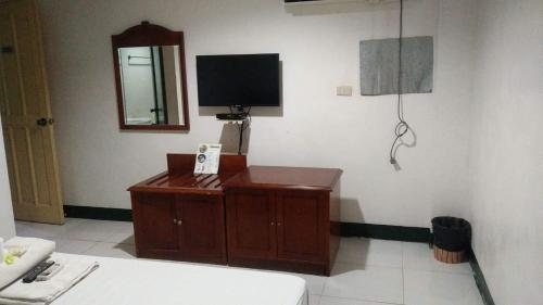 a living room with a tv and a wooden cabinet at Asia Novo Boutique Hotel - Cabuyao Laguna in Cabuyao