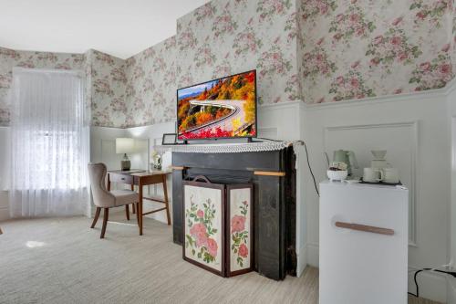 a living room with a television on top of a fireplace at 50 Lincoln Short North Bed & Breakfast in Columbus