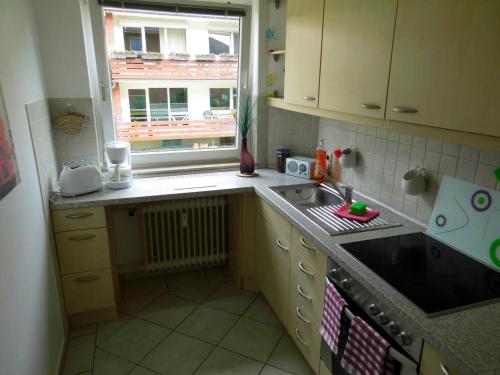 a small kitchen with a sink and a window at Maggie&#039s Goode Stuuv in Heiligenhafen