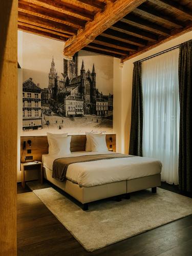 a bedroom with a bed with a painting on the wall at Hotel Harmony in Ghent