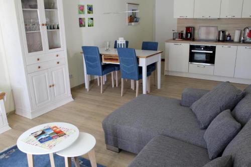 a living room with a couch and a table and a kitchen at Seeschwalbe App 34 in Neuhaus