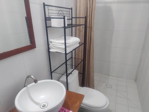 a bathroom with a white toilet and a sink at Club Cadena in Acapulco