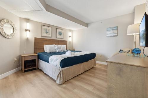 a bedroom with a bed and a sink in it at Ocean View King Suit at Landmark Heated Pools in Myrtle Beach