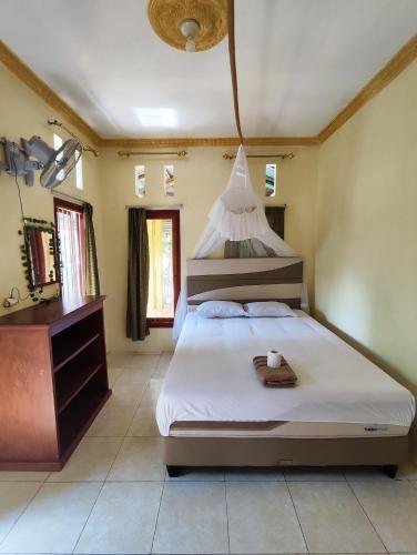a bedroom with a large bed and a dresser at FRANGKY HOMESTAY in Manado
