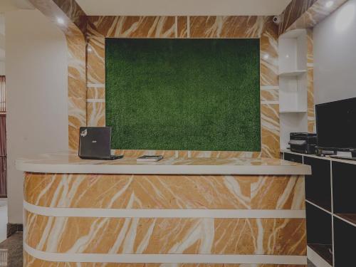 an office with a desk with a green painting on the wall at Hotel Navya Grand in Patna
