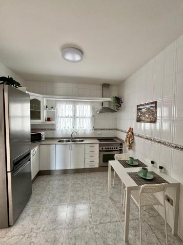 a kitchen with a stainless steel refrigerator and a table at Royal Home in Arrecife