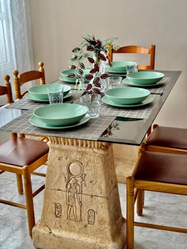 a dining room table with green plates on it at Royal Home in Arrecife