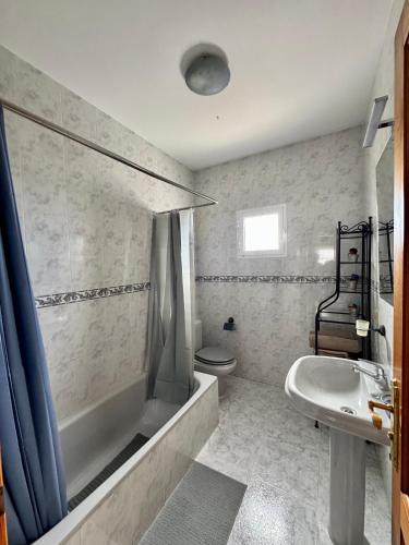 a bathroom with a tub and a toilet and a sink at Royal Home in Arrecife