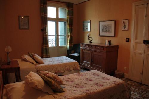una camera da letto con due letti e una finestra di Anges Gardiens a Villeneuve-lès-Béziers