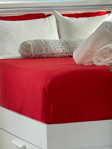 a red and white bed with two pillows on it at Studio close to airport in Dania Beach