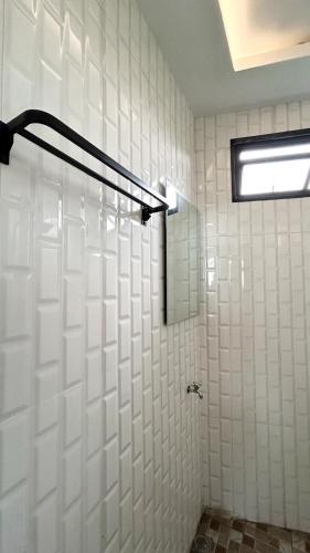 a bathroom with white tiled walls and a shower at Nimo Tea Resort in Tanara