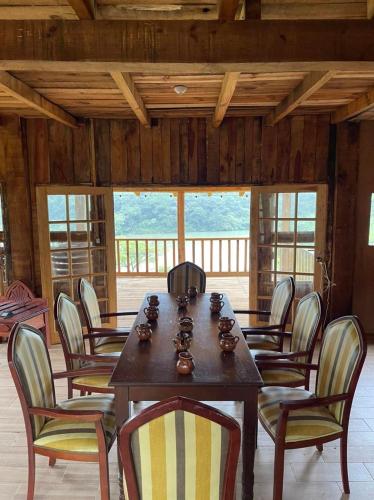 a dining room with a wooden table and chairs at Cabañas del Lago in Mascota