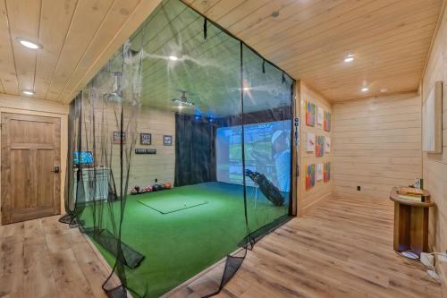 a room with a large room with a golf course in it at Honeybear Hideaways - #1 Luxury Haven Cabin with Breathtaking Mountain Views, Indoor Pool, Bowling Alley, and Golf in Pigeon Forge