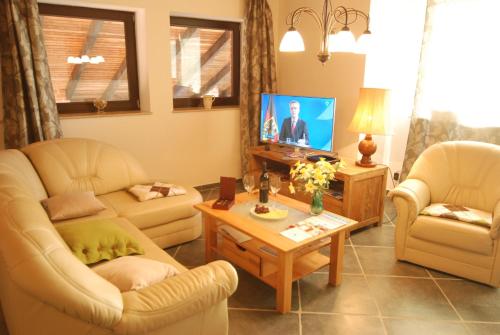 海利根港Ferienwohnung Leuchtturm的有两把椅子和一台电视的客厅