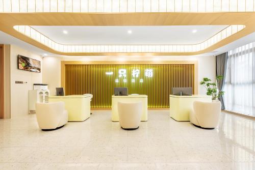 a lobby with white desks and white chairs at Lemon Hotel - Hangzhou West Lake Fengqi Road in Hangzhou