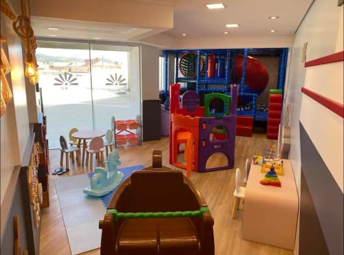 a childrens play room with a table and a play set at Apartamento aconchegante Mar Grosso in Laguna