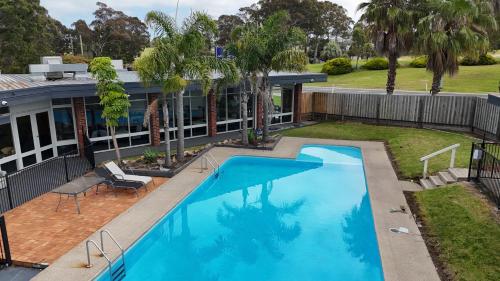 an overhead view of a swimming pool in front of a house at Ocean Views Motel Lakes Entrance in Lakes Entrance