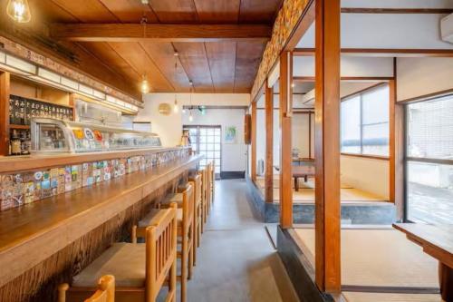 a restaurant with a long bar with benches at Guesthouse giwa - Vacation STAY 14252v in Mishima
