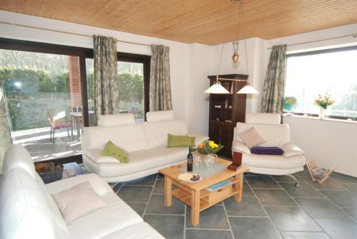 a living room with two white couches and a table at Ferienwohnung Muschel in Heiligenhafen