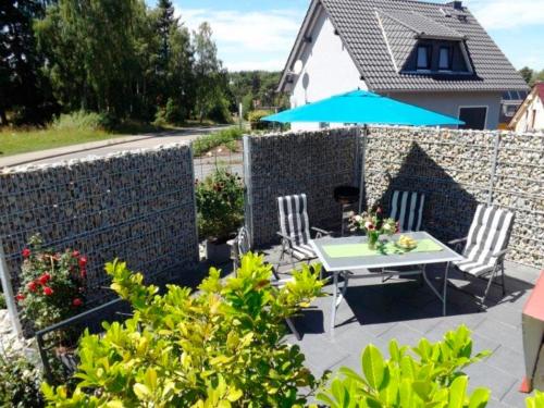 a garden with a table and chairs and a brick wall at Ferienhaus Paulchen im Müritz Seepark in Röbel