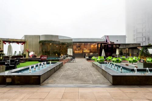 a building with a pool and tables and chairs at Grand Ion Genting Highlands in Genting Highlands