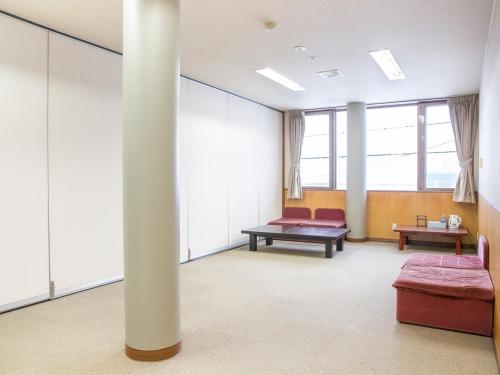 a hospital room with a column and a couch and tables at バードランド in Minami Uonuma