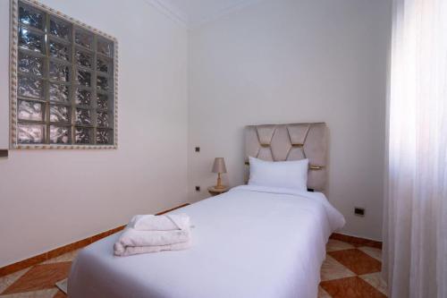 a bedroom with a large white bed and a window at Appartement Cosy et Confortable in Casablanca