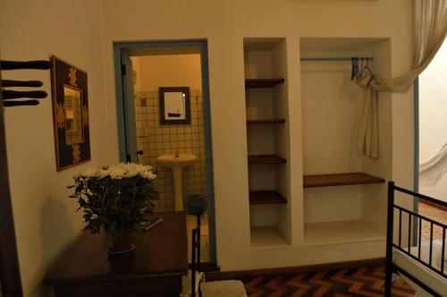 a hallway with a bathroom with a sink and a mirror at Pousada Baluarte in Salvador
