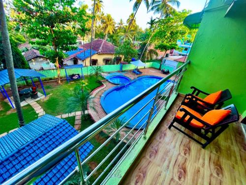 a balcony with chairs and a swimming pool at The calagute Beach Resort By Shivam Resort 1 km from beach in Candolim