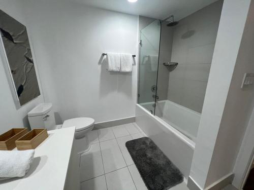 a white bathroom with a toilet and a shower at Miami Beach Cozy 1B withe Pool and Beach Service1507 in Hallandale Beach
