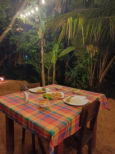 a table with plates of food on top at Turtle Island Cabana in Tangalle