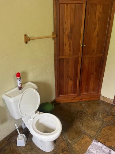 a bathroom with a toilet and a wooden cabinet at Magical Malewa Retreat in Naivasha