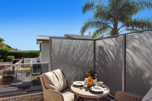 a patio with a table and chairs on a balcony at Sunny Daze - Ohope Beach Holiday Home in Ohope Beach