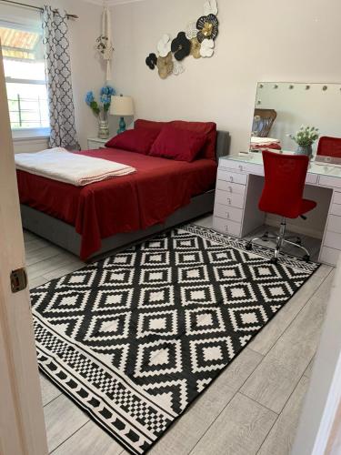 a bedroom with a bed and a desk and a red chair at Cheerful 2 BED ROOMS Apartment in heart of Queens in Jackson Heights